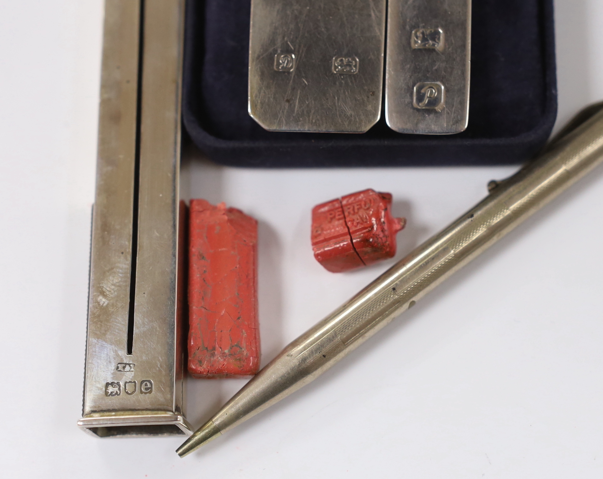 An Edwardian silver propelling wax seal dispenser/vesta, Birmingham, 1904, 13.7cm, two modern silver money clips and a Yard-O-Lead pencil.